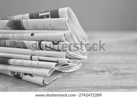 Stack of newspapers on wooden table, closeup