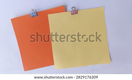 A stack of note papers is neatly secured by a binder clip, illustrating a practical method for organizing loose sheets and keeping important reminders or documents tidy and accessible