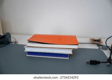 Stack of notebooks on modern workspace desk with copy space
