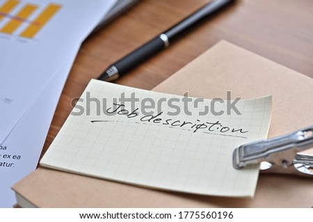 A stack of notes with the words "job description" written on them sits on my desk.
