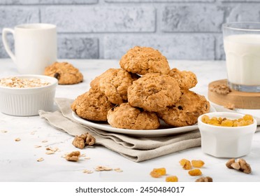 A stack of oatmeal cookies on a plate, raisins, walnuts, a glass of milk, a cup of coffee. Horizontal.
 - Powered by Shutterstock