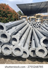 Stack of octagonal galvanized steel poles for street lighting or power distribution in a factory yard