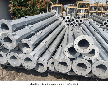 Stack of octagonal galvanized steel poles for street lighting or power distribution in a factory yard