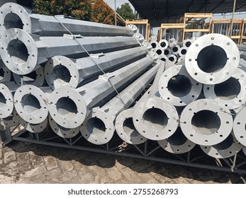 Stack of octagonal galvanized steel poles for street lighting or power distribution in a factory yard