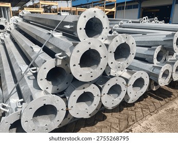 Stack of octagonal galvanized steel poles for street lighting or power distribution in a factory yard