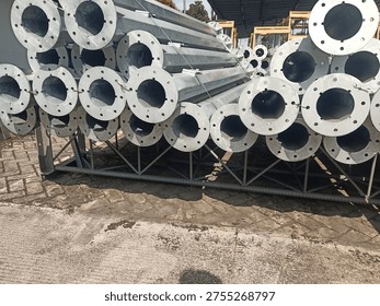 Stack of octagonal galvanized steel poles for street lighting or power distribution in a factory yard