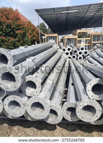 Stack of octagonal galvanized steel poles for street lighting or power distribution in a factory yard