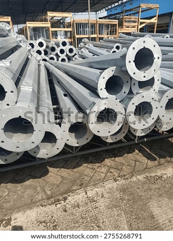 Stack of octagonal galvanized steel poles for street lighting or power distribution in a factory yard