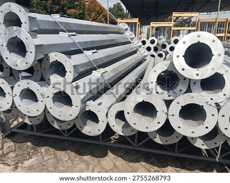 Stack of octagonal galvanized steel poles for street lighting or power distribution in a factory yard