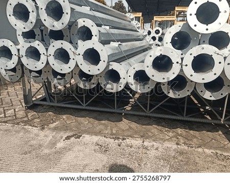 Stack of octagonal galvanized steel poles for street lighting or power distribution in a factory yard