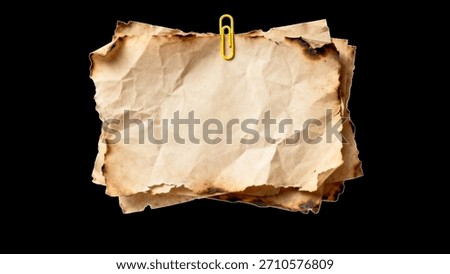 Stack of old, aged, burnt, and crumpled paper sheets with a yellow paperclip for a vintage texture background