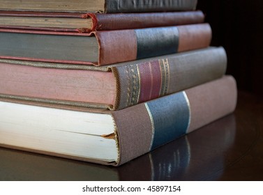 stack of old antique books on library table, shallow depth of field