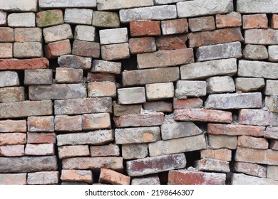 Stack of old bricks, some with moss on them