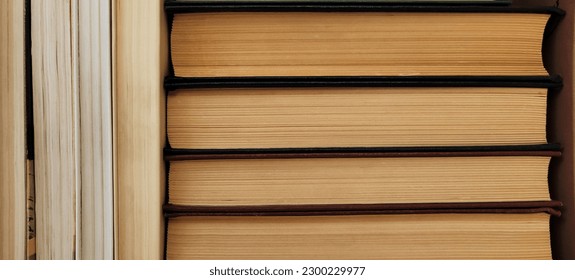 A stack of old, closed books with yellowed pages. The books appear weathered, with visible creases, marks, and frayed edges.