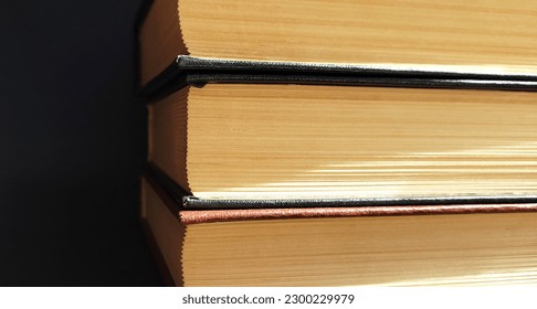 A stack of old, closed books with yellowed pages. The books appear weathered, with visible creases, marks, and frayed edges.