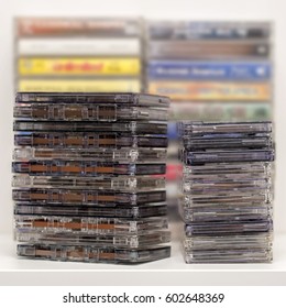 Stack of old dirty audio cassettes on the white shelf