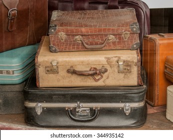 Stack Of Old Dirty Vintage Suitcases In A Thrift Store Window.