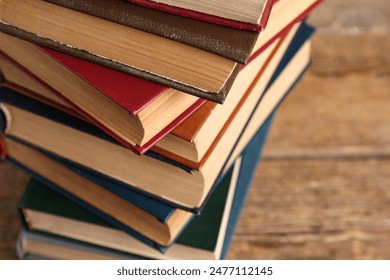 Stack of old hardcover books on wooden background, closeup - Powered by Shutterstock