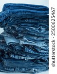 Stack of a stack of old jeans various shades of blue jeans. Denim jeans texture. Denim background texture for design. Canvas denim texture. Blue denim background.