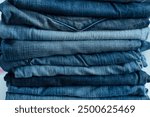 Stack of a stack of old jeans various shades of blue jeans. Denim jeans texture. Denim background texture for design. Canvas denim texture. Blue denim background.