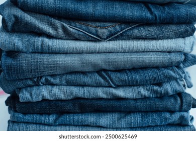 Stack of a stack of old jeans various shades of blue jeans. Denim jeans texture. Denim background texture for design. Canvas denim texture. Blue denim background.