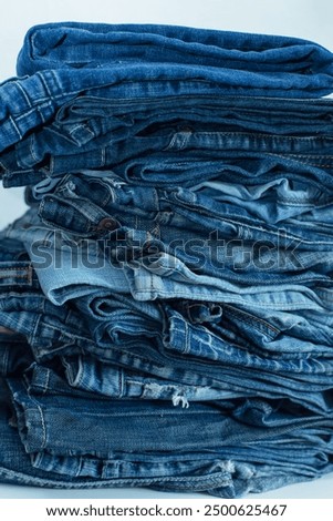Stack of a stack of old jeans various shades of blue jeans. Denim jeans texture. Denim background texture for design. Canvas denim texture. Blue denim background.
