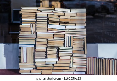 A stack of old and new books of different sizes and shapes stacked in a chaotic manner. Close-up.