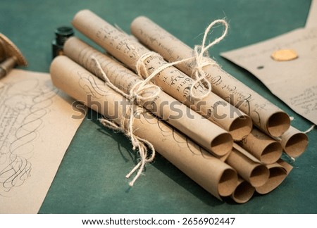 A stack of old parchment scrolls tied together with string. The scrolls are tied in a way that they are not touching each other