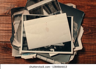 Stack old photos on table. Mock-up blank paper. Postcard rumpled and dirty vintage. Retro card