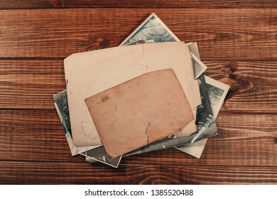 Stack old photos on table. Mock-up blank paper. Postcard rumpled and dirty vintage. Retro card