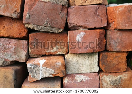 A stack of old red clay bricks and mortar from a salvaged chimney destruction.