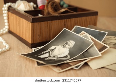 stack of old retro family sepia photos on table, vintage wooden box with dear heart memorabilia, concept of family tree, genealogy, home archive, memory of ancestors, childhood memories