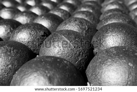 stack of old rusty cannon balls in black and white