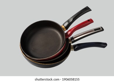 Stack of old scratched used pans on light gray background