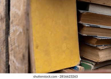 Stack of old secondhand books in hardcover and paperback with worn pages and covers, vintage literature on display at flea market or garage sale.