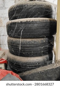 Stack of old used car tires covered with dust and cobwebs in dirty warehouse storage

A stack of four old and unused car tires covered with thick dust and cobwebs in a messy and dirty warehouse storage area.