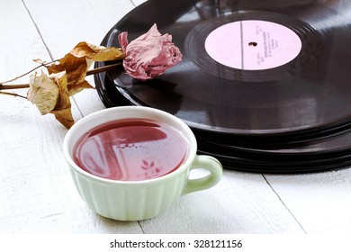 Stack of old vinyl records and audio cassette on white wooden table. Toned photo