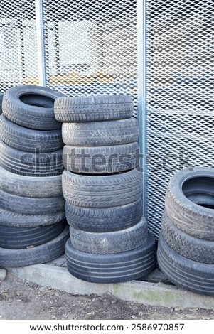 Car tire leaning against a pink wall