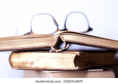 A stack of olf books and reading glasses