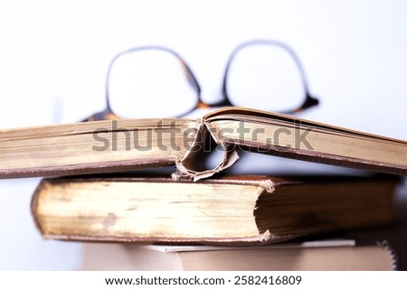 A stack of olf books and reading glasses