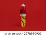stack on yellow cubes with percent signs and flying up rocketship on red background. Concept of buying and increasing cashback