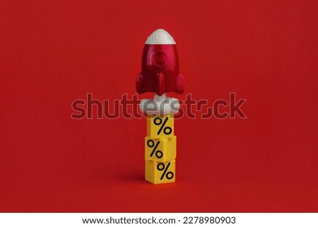 stack on yellow cubes with percent signs and flying up rocketship on red background. Concept of buying and increasing cashback