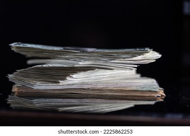 A stack of one dollar bills on a dark background.
