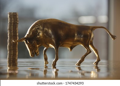 Stack of One Euro coins next to bull figurine Stock fotografie