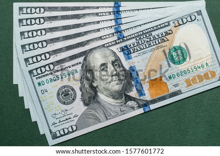 Stack of one hundred american dollars bills over green background.