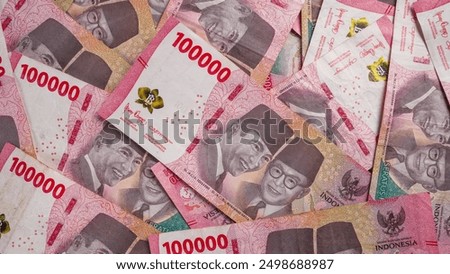 Stack of One Hundred Thousand Rupiah Banknotes in red or pink. Close-up shot of one hundred thousand rupiah banknotes. Indonesian Currency