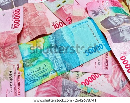Stack of One Hundred Thousand Rupiah Banknotes in red or pink. Close-up shot of one hundred thousand rupiah banknotes. Indonesian Currency. Cash payment concept. Indonesian rupiah currency. 