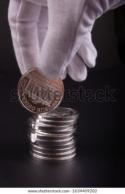 Stack\
of one ounce pure bullion silver investment coins on black\
background. Physical silver - secure investment.\
