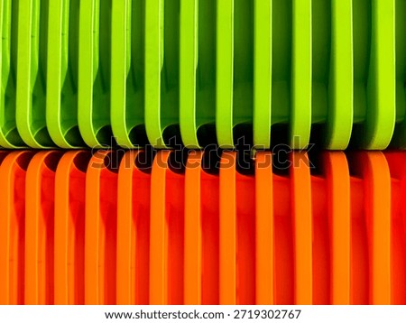A stack of orange and green plastic containers or organizers, perhaps for storage or kitchen purposes, makes a great backdrop.