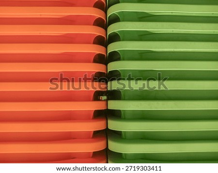 A stack of orange and green plastic containers or organizers, perhaps for storage or kitchen purposes, makes a great backdrop.